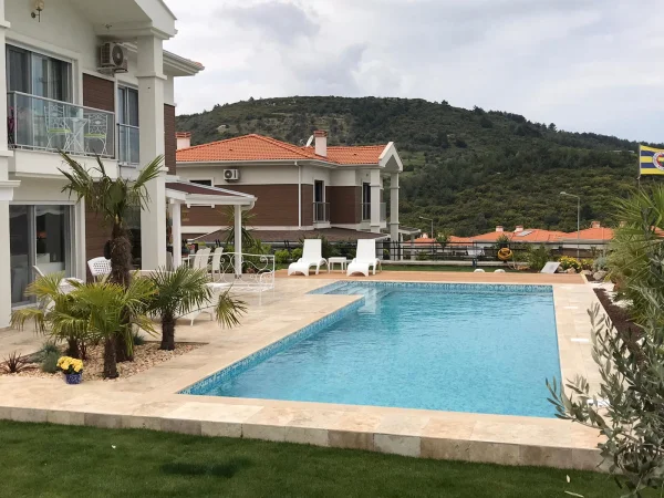 Urla Evi: Doğal Taş ve İroko Teraslı Mavi Cam Mozaik Havuz Tasarımı