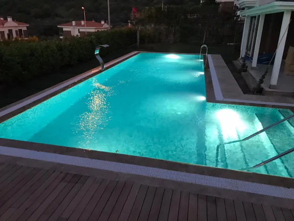 Sedefli Zümrüt Senfonisi: Üstten Taşmalı Su Perdeli Havuz ve Iroko & Traverten Konsepti Detay