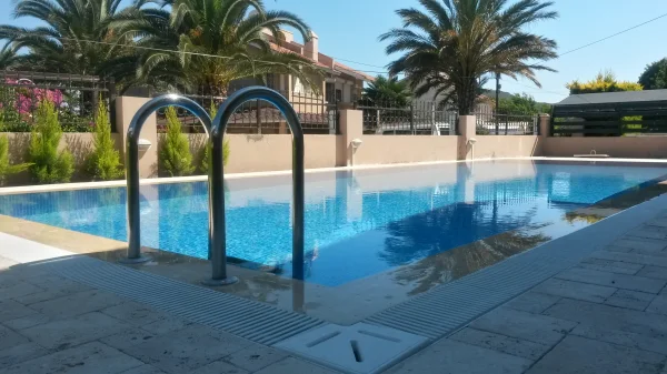 Çeşme'de Klasik Uyum: Traverten Teraslı ve Mavi Mozaikli Üstten Taşmalı Havuz Konsepti Detay