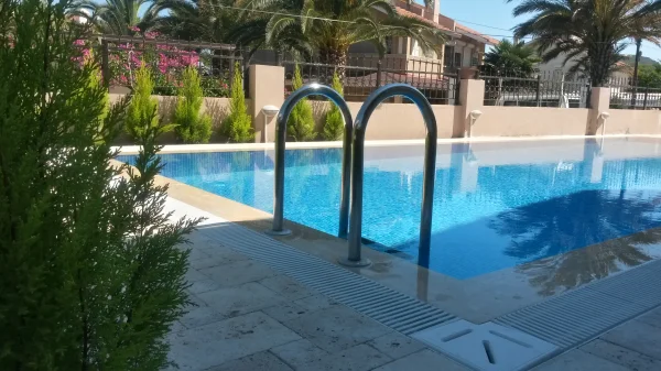 Çeşme'de Klasik Uyum: Traverten Teraslı ve Mavi Mozaikli Üstten Taşmalı Havuz Konsepti Detay
