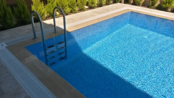 Çeşme'de Klasik Uyum: Traverten Teraslı ve Mavi Mozaikli Üstten Taşmalı Havuz Konsepti Detay