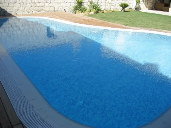 Mavi ve Ahşap Ahengi: Çeşme Üstten Taşmalı Havuz ve İroko Teras Projesi Detay